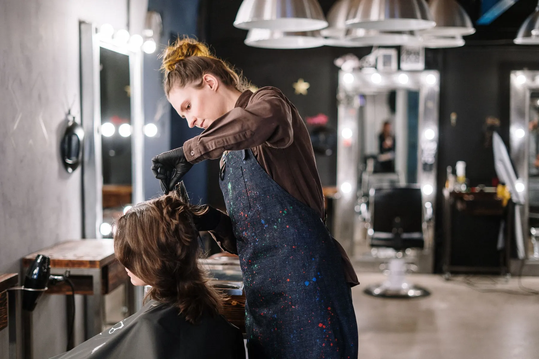 Une coiffeuse coupe les cheveux d’une cliente dans un salon